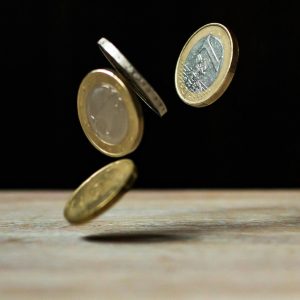 Angel investor's coin drop on a wood surface